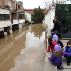 Una de las familias afectadas contempla la inundación por la crecida del río.