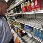 Un empresario extranjero busca agua embotellada en un supermercado de Tokio.