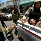 Soldados iraquíes evacúan a un compañero herido en los enfrentamientos del centro de Bagdad