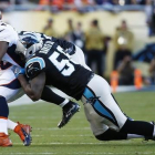 El running back de los Broncos J. Anderson, interceptado por Thomas Davis de los Carolina Panthers.