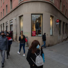 Varios transeúntes pasan ante un comercio del centro de Barcelona, ayer. ENRIC FONTCUBERTA