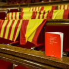 Los escaños del PPC, con banderas de España y de Cataluña y un ejemplar con la Constitución Española , el Estatuto de Cataluña y el Reglamento del Parlment.