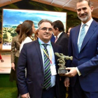 El pedáneo de San Facundo, Ricardo Vila, entregando a Don Felipe la escultura de la trucha. DL