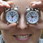 Una empleada del fabricante de relojes Carlton sostiene dos despertadores de la empresa, este viernes en Múnich, para recordar sobre el cambio de hora.