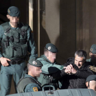 Agentes de la Guardia Civil trasladan a uno de los detenidos tras un registro en Bilbao.