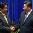 El primer ministro de Japón, Shinzo Abe (izquierda),y el presidente de China, Xi Jinping, se saludan, este lunes en Pekín.