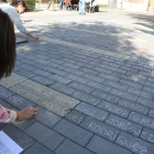 Dos jóvenes escriben en tiza en la plaza de San Marcos los nombres de los presos y represaliados de la Guerra Civil