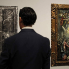 Un visitante observa dos de las obras de la muestra.