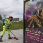 Un barrendero de León durante el confinamiento por la pandemia, con el cartel del musical que llegará en junio a León. JESÚIS F. SALVADORES
