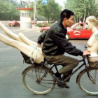 Un joven atraviesa las calles de Beijiing con un maniquí en su bicicleta, en una imagen de archivo.
