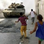 Niños palestinos tiran piedras contra un tanque israelí en Yenín