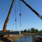 Las grúas están colocando las vigas sobre el cauce del río