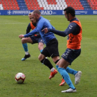 Isi se va entre dos jugadores del Lugo con la lluvia como telón de fondo en el partidillo jugado ayer en el Anxo Carro. CD LUGO