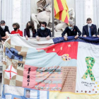 Pere Aragonès y otros cargos del Govern despliegan ayer en el balcón del Palau de la Generalitat el Tapiz Memorial del Sida. QUIQUE GARCÍA