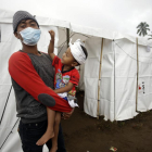 Un padre y su hijo tras ser evacuados a causa de la erupción del volcán Agung.