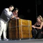Dos voluntarios ayudan a encerrar a uno de los artistas en una caja de la que salió sin abrirla