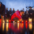 El parlamentario del SPD Yüksel y una niña encienden velas en homenaje a las víctimas.