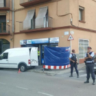 Agentes de los Mossos custodian la puerta de un locutorio de Ripoll registrado en relación con los atentados de Barcelona y Cambrils.