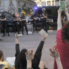 Un grupo de estudiantes protesta alzando libros con las manos ante la policía impasible.