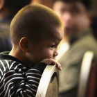 Un niño de tres años, familiar de un pasajero del avión de Malaysia Airlines, espera en un hotel de Pekín, este lunes.