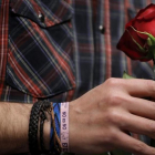 Iglesias sostiene una rosa con la mano en la que luce una pulsera podemista con el lema de Sánchez contra la abstención del PSOE en la investidura de Rajoy.