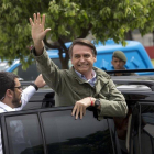 Bolsonaro saluda a sus seguidores tras depositar su voto.