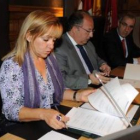 Isabel Carrasco analiza el documento antes de su firma al lado del delegado de la Junta, Eduardo Fer