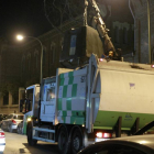 Imagen de un camión de recogida nocturna de basuras retirando un contenedor en la madrileña calle de Alonso Cano.