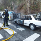 Un bombero junto al coche calcinado. BOMBEROS PONFERRADA