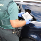 Un guardia civil porta el paquete con la cocaína interceptada en un vehículo en Trabadelo. DL