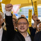 De izquieda a derecha, Chu Yiu-ming, Benny Tai y Chan Kin-man, saludan a su seguidores antes de entrar en el tribunal de West Kowloon en Hong Kong.