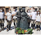 Los representantes municipales con los alumnos del taller junto a la escultura de los hortelanos. DL