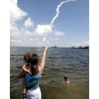 Una mujer muestra a su hijo la estela de humo dejada por el «Atlantis»
