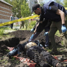 Un soldado ucraniano saca de una zanja el cadáver de un civil asesinado en la ciudad de Járkov. VASILIY ZHLOBSKY
