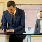 Pedro Sánchez firma el acuerdo presupuestario ante la mirada de Pablo Iglesias, en la Moncloa
