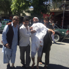 Tres personas ayudan a un hombre herido en el atentado de este miércoles en Kabul.