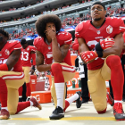 Colin Kaepernick, de rodillas mientras suena el himno de EEUU.