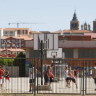 Unos jóvenes juegan al baloncesto en las instalaciones municipales de Astorga.
