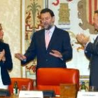Ana Mato y Luis de Grandes aplauden a su secretario general, Mariano Rajoy, al finalizar su discurso