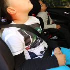 Dos niños sobre los soportes especiales de protección infantil en un vehículo. DL
