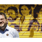 Pere Aragonés ante una trapa pintada con los rostros de los políticos presos en el barrio de Gracia, en Barcelona. ANDREU DALMAU