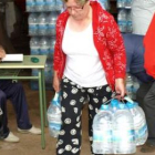 Una vecina de Zuares del Páramo recoge sus botellas de agua hace unos días.