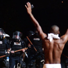 Un joven levanta los brazos ante la policía en Charlotte.