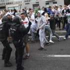 Aficionados del Legia se enfrentan a agentes de la Policia Nacional antes del comienzo del partido del martes contra el Madrid.