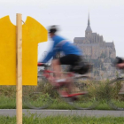 Uno ciclistas pasan cerca del Mont de Saint Michel, donde el sábado comienza el Tour.