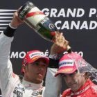 El piloto británico Lewis Hamilton, a la izquierda, moja con champán al piloto español Fernando Alon