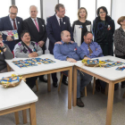 Autoridades participantes en la inauguración junto a un grupo de personas que realizan trabajos manuales. FERNANDO OTERO PERANDONES