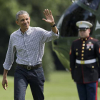 Obama saluda a los fotógrafos a su llegad a la Casa Blanca procedente de Camp David, este domingo.
