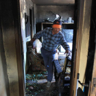 El padre del afectado recorre la vivienda después de que los bomberos sofocaran las llamas.