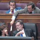 Mariano Rajoy y Soraya Sáenz de Santamaría hablan en el banco azul mientras Rafael Hernando les pasa una nota.